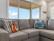 Living room with a comfortable sofa, accent pillows, and a view of the pool patio offering a cozy relaxation space at 3036 Parrot Head Pl, Kissimmee, FL 34747