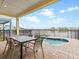 Enjoy the outdoor covered patio with a splash pool, table and chairs with a lake view at 3036 Parrot Head Pl, Kissimmee, FL 34747