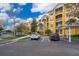View of the condo building's parking area, showcasing the architectural style and manicured landscaping at 3338 Robert Trent Jones Dr # 203, Orlando, FL 32835