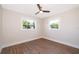 Bright bedroom featuring two windows, modern ceiling fan, and durable wood flooring at 3403 Canute Pl, Orlando, FL 32818