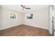 Cozy bedroom featuring modern ceiling fan, two windows, and durable wood flooring at 3403 Canute Pl, Orlando, FL 32818