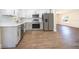 Modern open kitchen with stainless steel appliances, white cabinets, and hardwood flooring at 3403 Canute Pl, Orlando, FL 32818