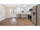 Bright kitchen with stainless steel appliances, white cabinets, and durable wood flooring at 3403 Canute Pl, Orlando, FL 32818