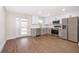 Bright kitchen with stainless steel appliances, white cabinets, and durable wood flooring at 3403 Canute Pl, Orlando, FL 32818