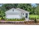 Charming single-story home featuring a two-car garage, landscaped yard, and inviting entryway with lush greenery at 3438 Briarwood Grove Dr, Ocoee, FL 34761