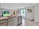 Spacious kitchen island with granite countertop, stainless steel appliances, and views of the living space and sliding glass doors at 3438 Briarwood Grove Dr, Ocoee, FL 34761