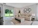 Bright living room with neutral tones, stylish decor, and sliding glass doors leading to outdoor space at 3438 Briarwood Grove Dr, Ocoee, FL 34761