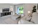 Cozy living room features a plush white sofa, modern furniture, and sliding glass doors to the backyard at 3438 Briarwood Grove Dr, Ocoee, FL 34761