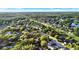 Wide aerial view of leafy community showing trees, residential streets, homes and lake at 3499 Woodley Park Pl, Oviedo, FL 32765