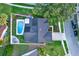 A bird's-eye view of the property, featuring a pool, patio with firepit, and well-manicured lawn at 3499 Woodley Park Pl, Oviedo, FL 32765