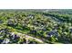 Scenic aerial view of a residential neighborhood with mature trees, green spaces, and a tranquil pond at 3499 Woodley Park Pl, Oviedo, FL 32765