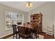 Bright dining area with a wooden table set, hutch, large window, and hardwood floors creating a welcoming atmosphere at 3499 Woodley Park Pl, Oviedo, FL 32765