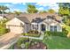 Eye-level shot of single-story home showcasing fresh landscaping, well-kept lawn, and convenient attached garage at 3499 Woodley Park Pl, Oviedo, FL 32765
