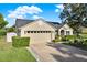 Attractive single-story house displaying well-maintained landscaping, green lawn, and a spacious attached garage with driveway at 3499 Woodley Park Pl, Oviedo, FL 32765