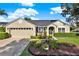 Inviting home exterior featuring manicured landscaping, a well-kept lawn, and an attached garage with driveway at 3499 Woodley Park Pl, Oviedo, FL 32765