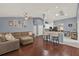 Open-concept living room featuring modern furniture, ceiling fan, and dark wood flooring at 3499 Woodley Park Pl, Oviedo, FL 32765