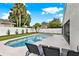 Inviting backyard pool with lounge chairs, a privacy fence, and mature trees at 3499 Woodley Park Pl, Oviedo, FL 32765