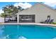 A backyard pool, with a screened porch and outdoor seating, and an area for lounge chairs at 3499 Woodley Park Pl, Oviedo, FL 32765