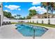 Backyard pool with a white fence, greenery, lounge chairs and patio table in a well-landscaped yard at 3499 Woodley Park Pl, Oviedo, FL 32765