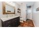 Updated bathroom features a dark vanity with marble countertops, and wood framed mirror at 356 Remington Dr, Oviedo, FL 32765