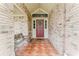 Charming covered porch with brick walls, decorative tile flooring, and a welcoming front door at 356 Remington Dr, Oviedo, FL 32765
