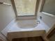 Close-up of a large, bright white bathtub under a window with blinds at 3707 Andover Cay Blvd, Orlando, FL 32825