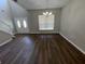 Open-concept living space featuring dark wood-look flooring, white trim and staircase, and a bright front entrance at 3707 Andover Cay Blvd, Orlando, FL 32825