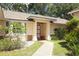 Inviting front entrance features a red door, neutral-colored exterior, and walkway leading to a welcoming home at 4035 Palo Alto Ct, Orlando, FL 32817
