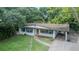 Aerial view of a white single-story home with blue shutters and a brick driveway and carport at 409 E Gulley Ave, Oakland, FL 34760