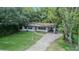Overhead view of charming single-story home with a brick driveway and lush landscaping at 409 E Gulley Ave, Oakland, FL 34760