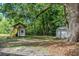 Backyard boasts a playhouse with slide, storage shed, and lush green space, creating a perfect play area at 409 E Gulley Ave, Oakland, FL 34760