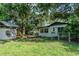 Spacious backyard with a large playhouse and mature trees providing shade at 409 E Gulley Ave, Oakland, FL 34760