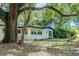 Large backyard with mature trees, a playset, and fencing at 409 E Gulley Ave, Oakland, FL 34760