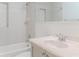 Bathroom with white tile, shower-tub, sink, and neutral colors throughout at 409 E Gulley Ave, Oakland, FL 34760