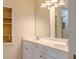 Bright bathroom showcases a double sink vanity, large mirror, and built in shelves at 409 E Gulley Ave, Oakland, FL 34760