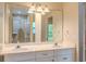 Bright bathroom features a double sink vanity, large mirror, and a glass-enclosed shower at 409 E Gulley Ave, Oakland, FL 34760