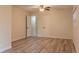 Spacious bedroom with wood-look flooring, ceiling fan, and access to bathroom at 409 E Gulley Ave, Oakland, FL 34760