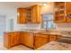 Well-lit kitchen featuring granite countertops, tile backsplash, and custom wood cabinets at 409 E Gulley Ave, Oakland, FL 34760