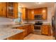 Well-appointed kitchen with stainless steel appliances, wood cabinetry, and granite countertops at 409 E Gulley Ave, Oakland, FL 34760