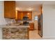 Charming kitchen featuring granite countertops, stainless steel appliances, and stone accents at 409 E Gulley Ave, Oakland, FL 34760