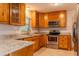 Kitchen with granite counters, stainless appliances, wood cabinets, and tiled flooring at 409 E Gulley Ave, Oakland, FL 34760