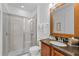 Bright bathroom with a glass-enclosed shower, granite countertops, and a decorative mirror at 441 Novi Path, Kissimmee, FL 34747
