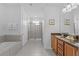 Luxurious bathroom with a bathtub, a glass-enclosed shower, and double sinks at 441 Novi Path, Kissimmee, FL 34747