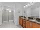 Bathroom featuring a double vanity, granite countertops, and tiled shower with glass door at 441 Novi Path, Kissimmee, FL 34747