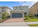 Charming home with a two-car garage and a lovely brick paved driveway, surrounded by mature landscaping at 441 Novi Path, Kissimmee, FL 34747