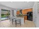 Open kitchen with modern cabinetry, granite counters, and backyard views from the breakfast bar at 441 Novi Path, Kissimmee, FL 34747