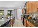 Stylish kitchen with granite countertops, a tiled backsplash, and seamless flow to outdoor spaces at 441 Novi Path, Kissimmee, FL 34747