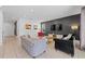 Modern living area with stylish sofas, a large TV, contemporary art, and easy access to other living spaces at 441 Novi Path, Kissimmee, FL 34747