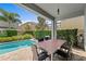 Covered patio with outdoor dining area overlooking the pool at 441 Novi Path, Kissimmee, FL 34747
