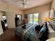 Comfortable bedroom features a dresser with TV, closet, and sliding glass doors to outdoor pool at 446 Summer Place Loop, Clermont, FL 34714